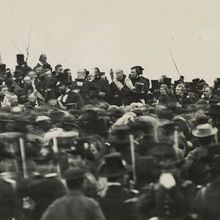 In one of the only known photos of Abraham Lincoln taken on the day of the Gettysburg Address, Lincoln can be seen seated, hatless, just below and to the right of the flag. Lincoln began developing symptoms of smallpox on the train home to Washington, DC.