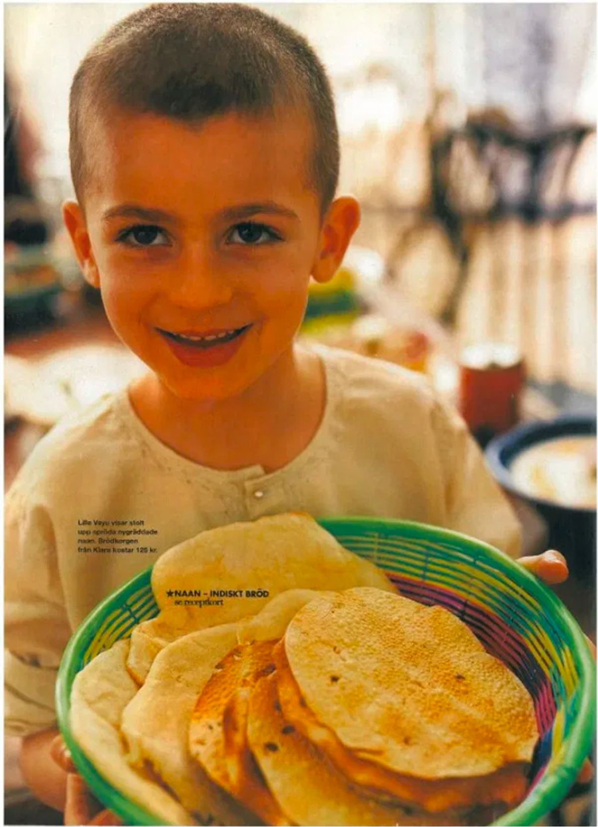 Photograph of a young Vayu Hill-Maini holding a basket of flatbreads. Photograph of a young Vayu Hill-Maini holding a basket of flatbreads.