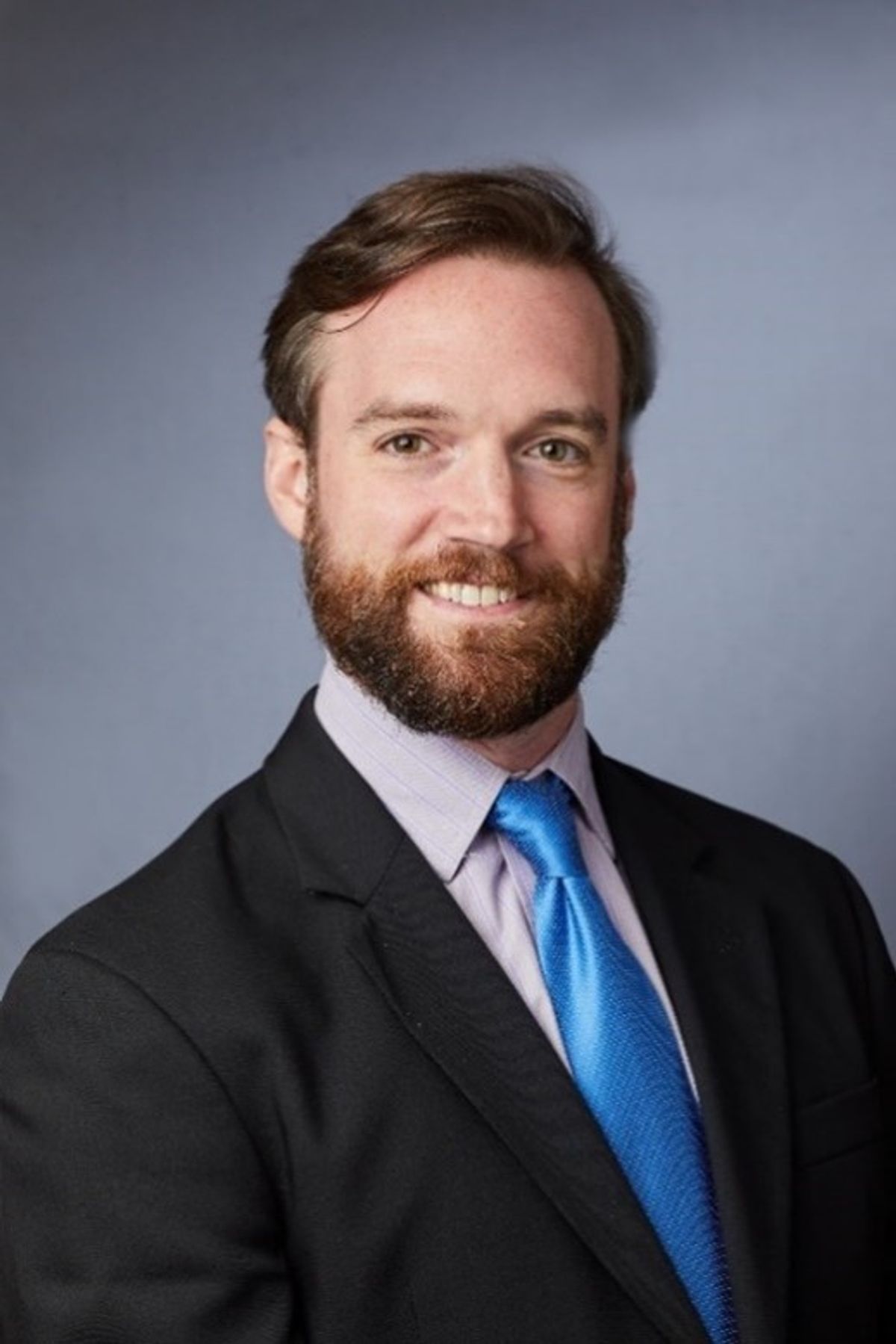 A headshot of Greg Tietjen, who is wearing a black suit and a blue tie. A headshot of Greg Tietjen, who is wearing a black suit and a blue tie.